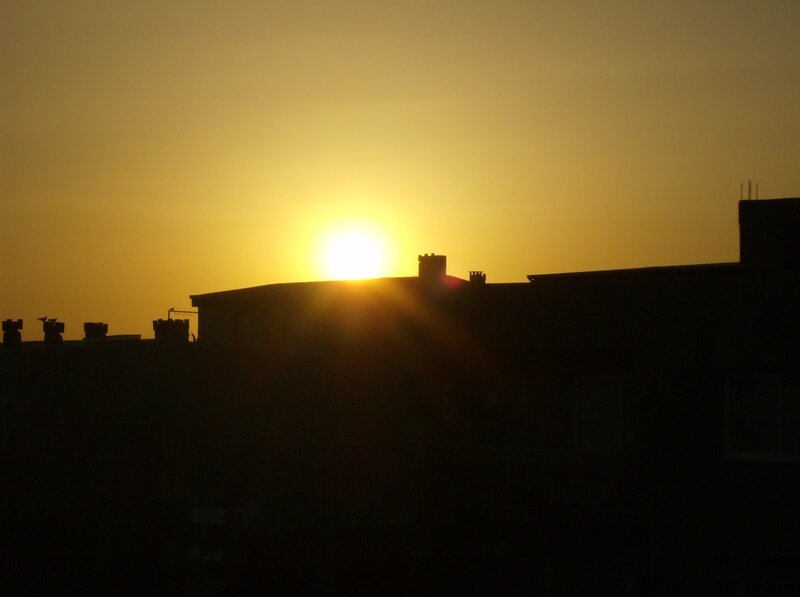 Sun Setting Behind Buildings — Yellow