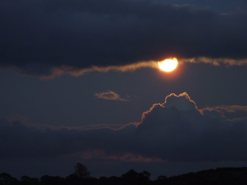 Sun setting behind clouds