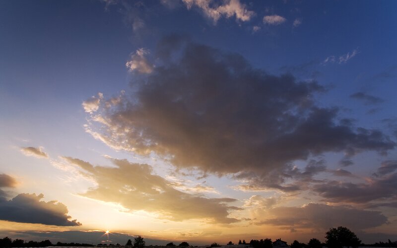 Sun Setting Behind Clouds — Blue, Dramatic, Sunset, Photograph, Trees, House, Orange, Yellow
