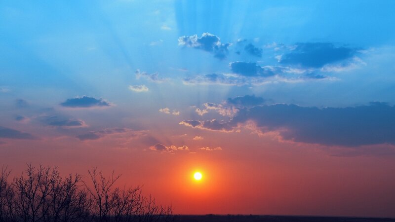 Sun Setting Behind Clouds — Blue, Serene, Sunset, Photograph, Trees