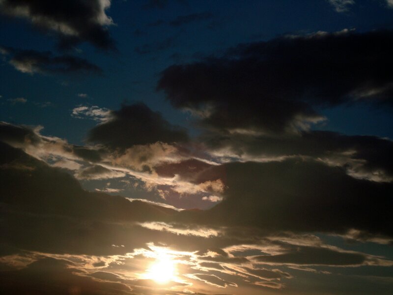 Sun Setting Behind Clouds — Blue