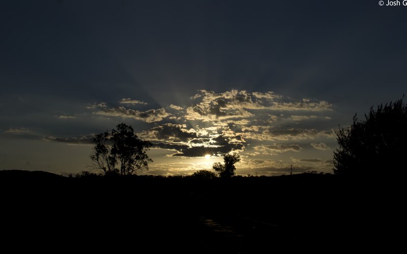 Sun Setting Behind Clouds — Dark Blue