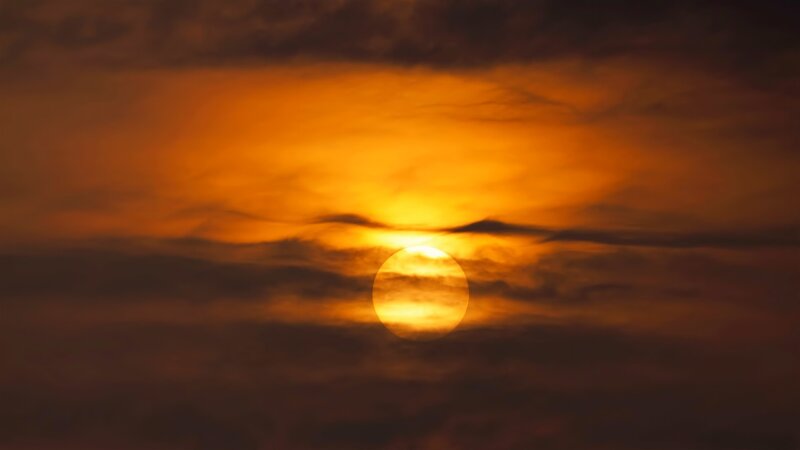 Sun Setting Behind Clouds — Dramatic, Brown