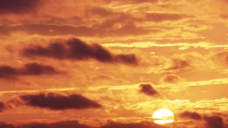Sun Setting Behind Clouds — Dramatic, Yellow