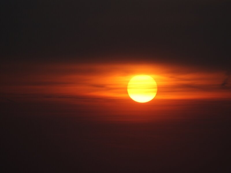Sun Setting Behind Clouds — Photograph, Yellow