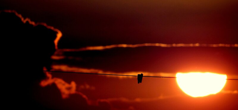 Sun Setting Behind Clouds — Red, Dramatic, Sunset, Photograph, Clothesline