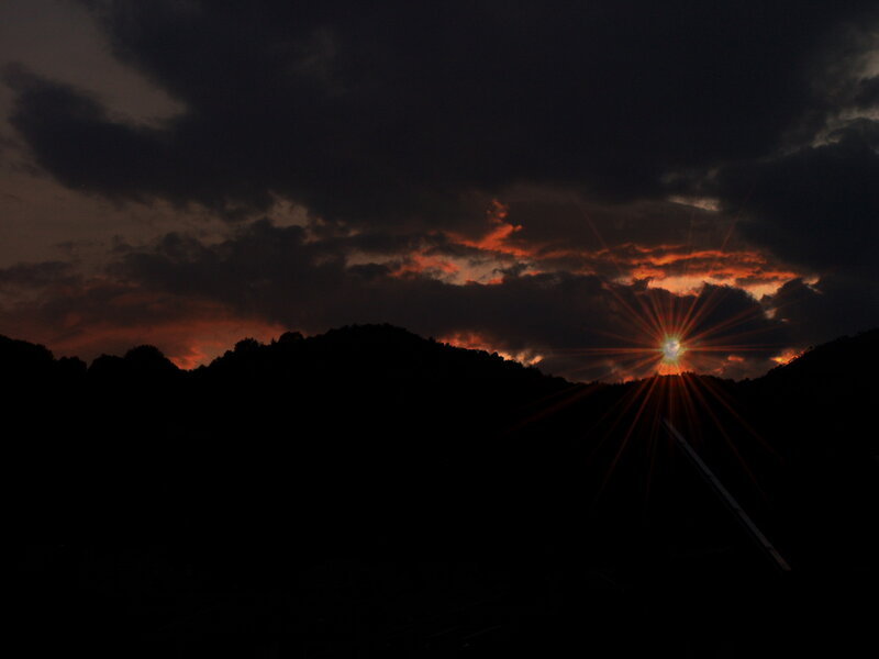 Sun Setting Behind Hills — Black