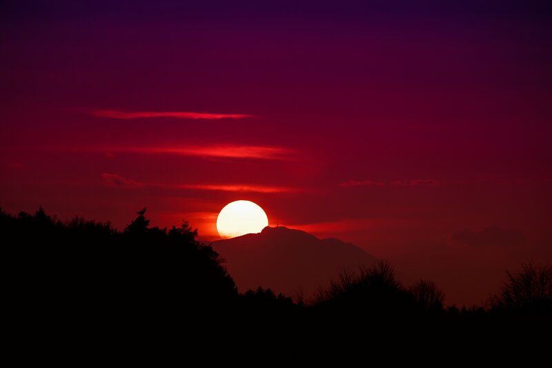 Sun Setting Behind Mountain — Red