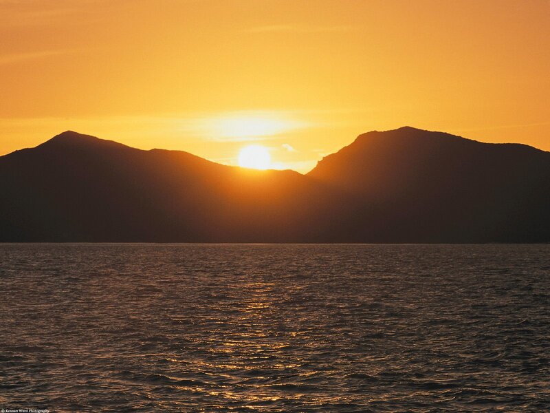 Sun Setting Behind Mountains — Orange, Serene, Sunset, Photograph, Sea