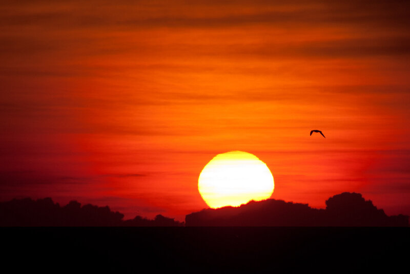 Sun Setting over Clouds — Red