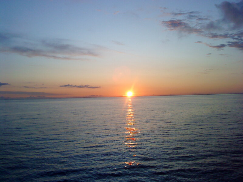 Sun Setting over Ocean — Blue, Clouds