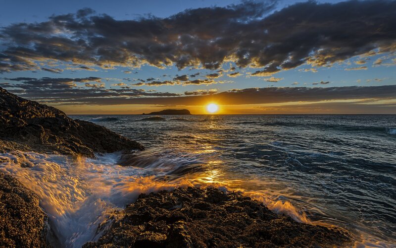 Sun Setting over Ocean — Blue, Dramatic, Sunset, Photograph, Clouds, Rocks, Island