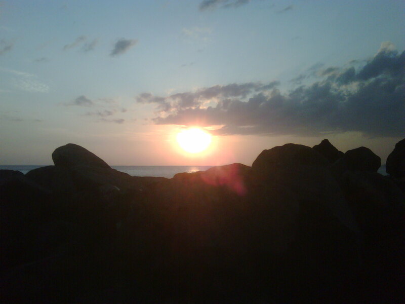 Sun Setting over Ocean — Blue, Serene, Sunset, Photograph, Rocks, Clouds, Orange