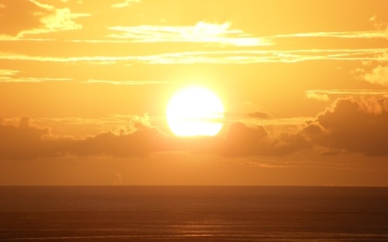 Sun Setting over Ocean — Brown