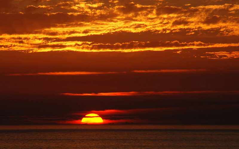 Sun Setting over Ocean — Clouds