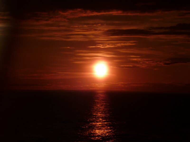 Sun Setting over Ocean — Dramatic, Black