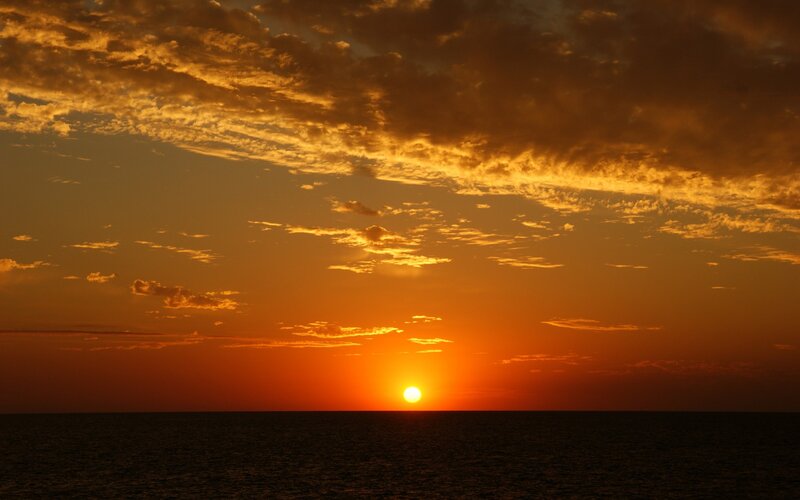 Sun Setting over Ocean — Dramatic, Clouds