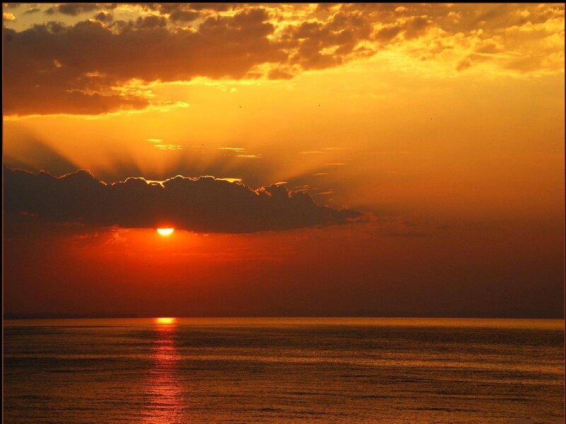 Sun Setting over Ocean — Dramatic, Yellow