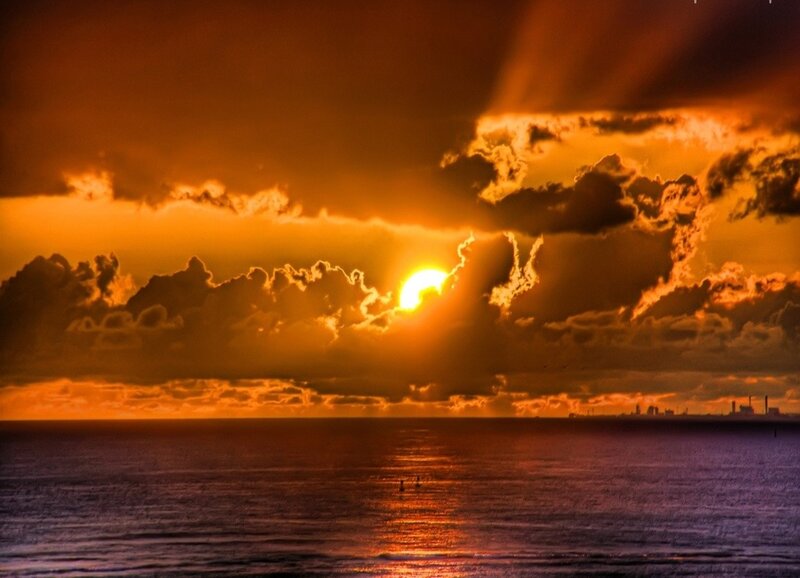 Sun Setting over Ocean — Orange, Dramatic, Sunset, Photograph, Clouds, City Skyline