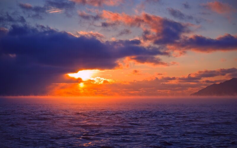 Sun Setting over Ocean — Orange, Dramatic, Sunset, Photograph, Clouds, Mountain