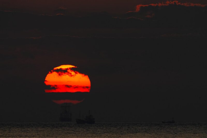 Sun Setting over Ocean — Red, Dramatic, Sunset, Photograph, Boats