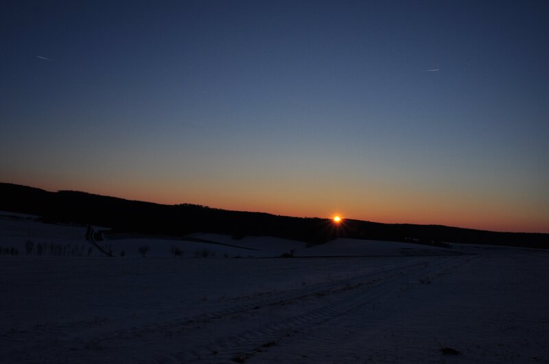 Sun Setting over Snowy Field