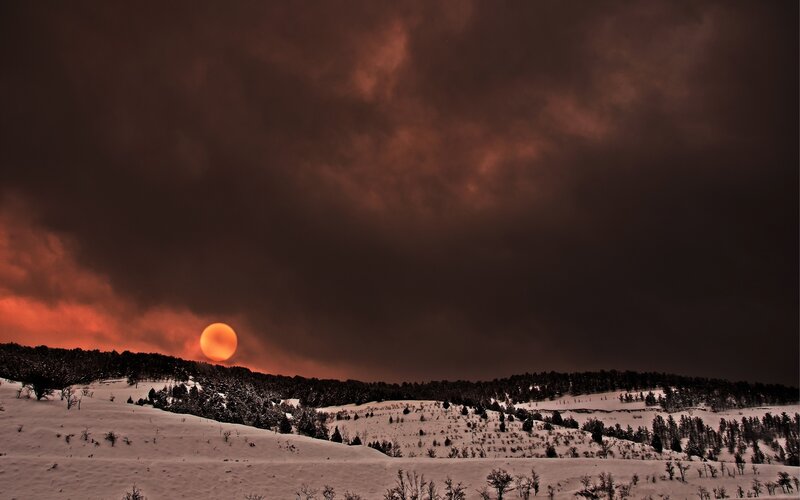 Sun Setting over Snowy Hills