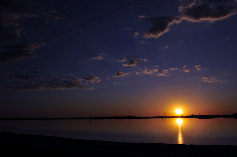 Sun Setting over Water — Blue, Serene, Sunset, Photograph, Clouds, Power Lines