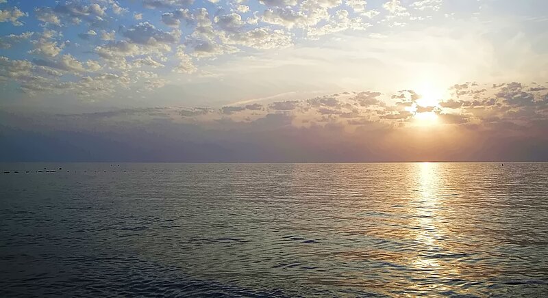Sun Setting over Water — Blue, Serene, Sunset, Photograph, Sky, Clouds