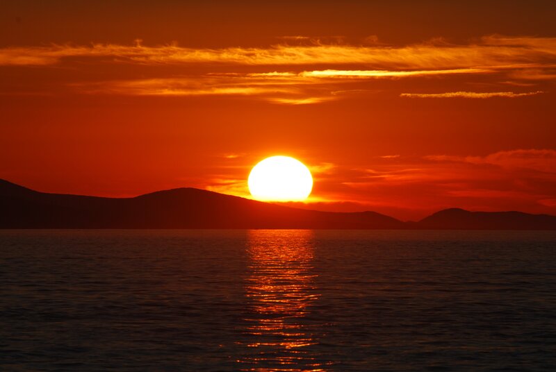 Sun Setting over Water — Orange, Dramatic, Sunset, Photograph, Mountains, Sky, Reflection