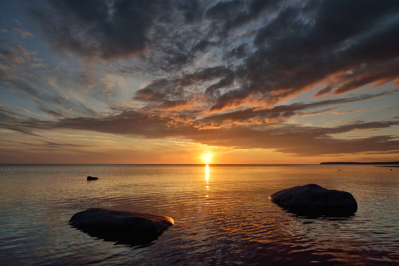 Sun Setting over Water — Orange, Serene, Sunset, Photograph, Rocks, Clouds