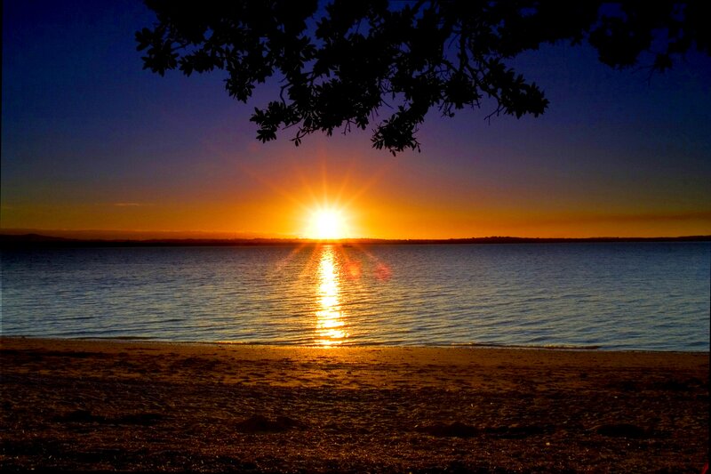 Sun Setting over Water — Orange, Serene, Sunset, Photograph, Tree Branch