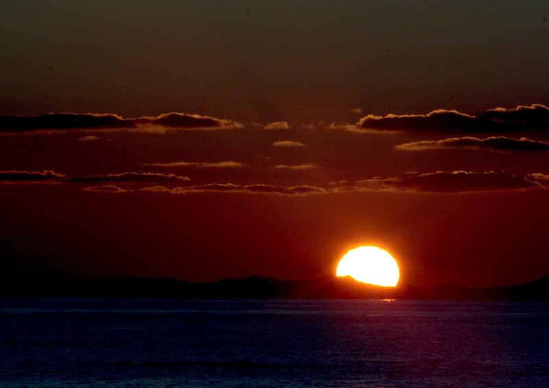 Sun Setting over Water — Red, Dramatic, Sunset, Photograph, Clouds, Mountains, Sea