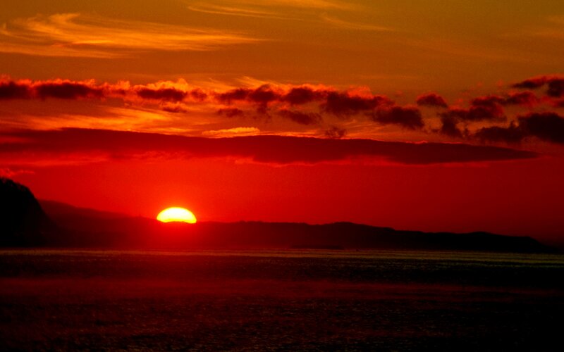 Sun Setting over Water — Red, Dramatic, Sunset, Photograph, Clouds, Mountains