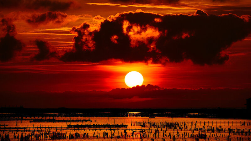 Sun Setting over Water — Red, Dramatic, Sunset, Photograph, Clouds, Pilings