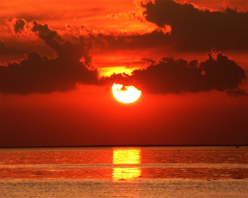 Sun Setting over Water — Red, Dramatic, Sunset, Photograph, Clouds