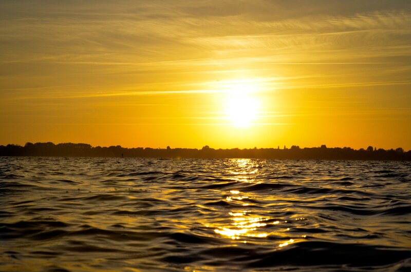 Sun Setting over Water — Yellow, Serene, Sunset, Photograph, Sky, Trees