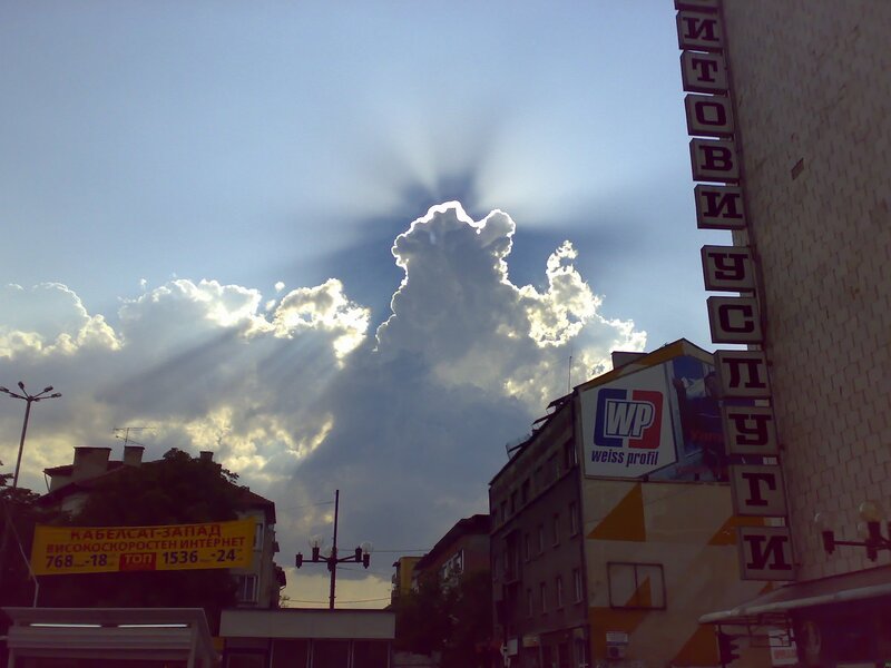 Sunbeams through clouds over city