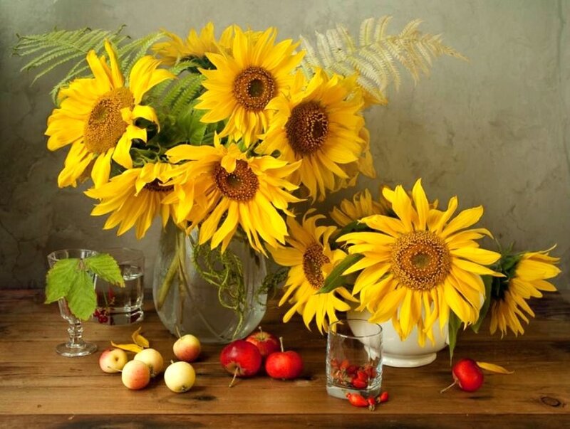 Sunflowers and fruit on a wooden table