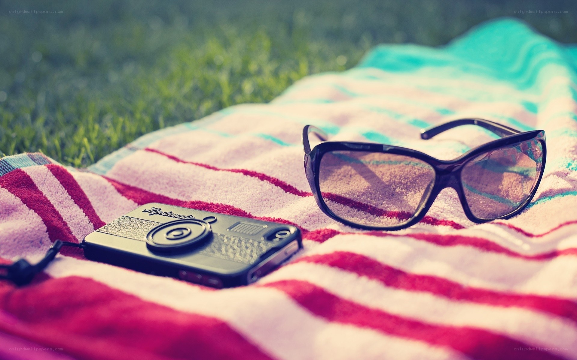 Sunglasses and camera on towel