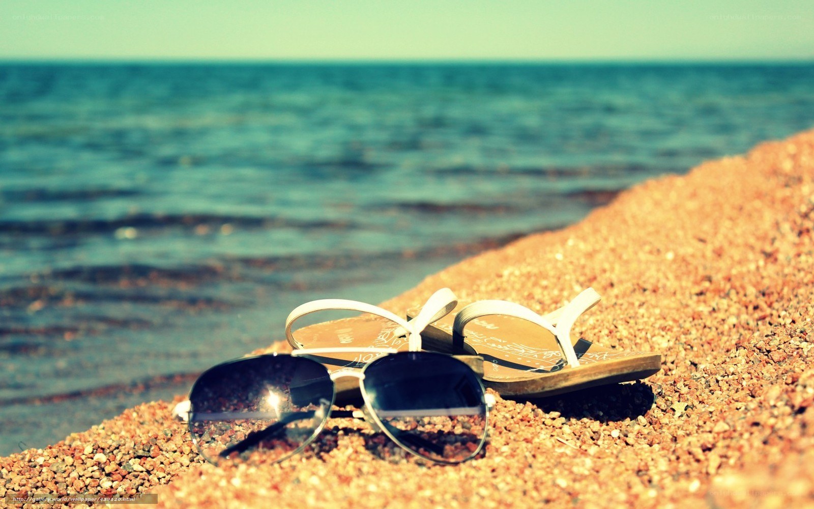 Sunglasses and sandals on the beach