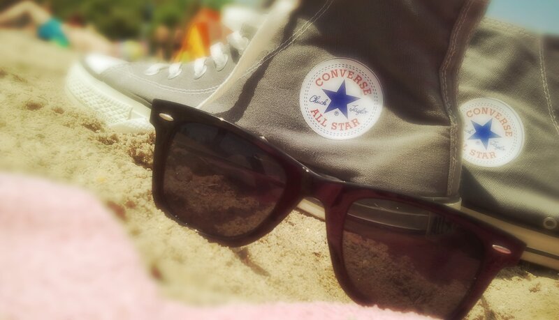 Sunglasses and Shoes on Sand