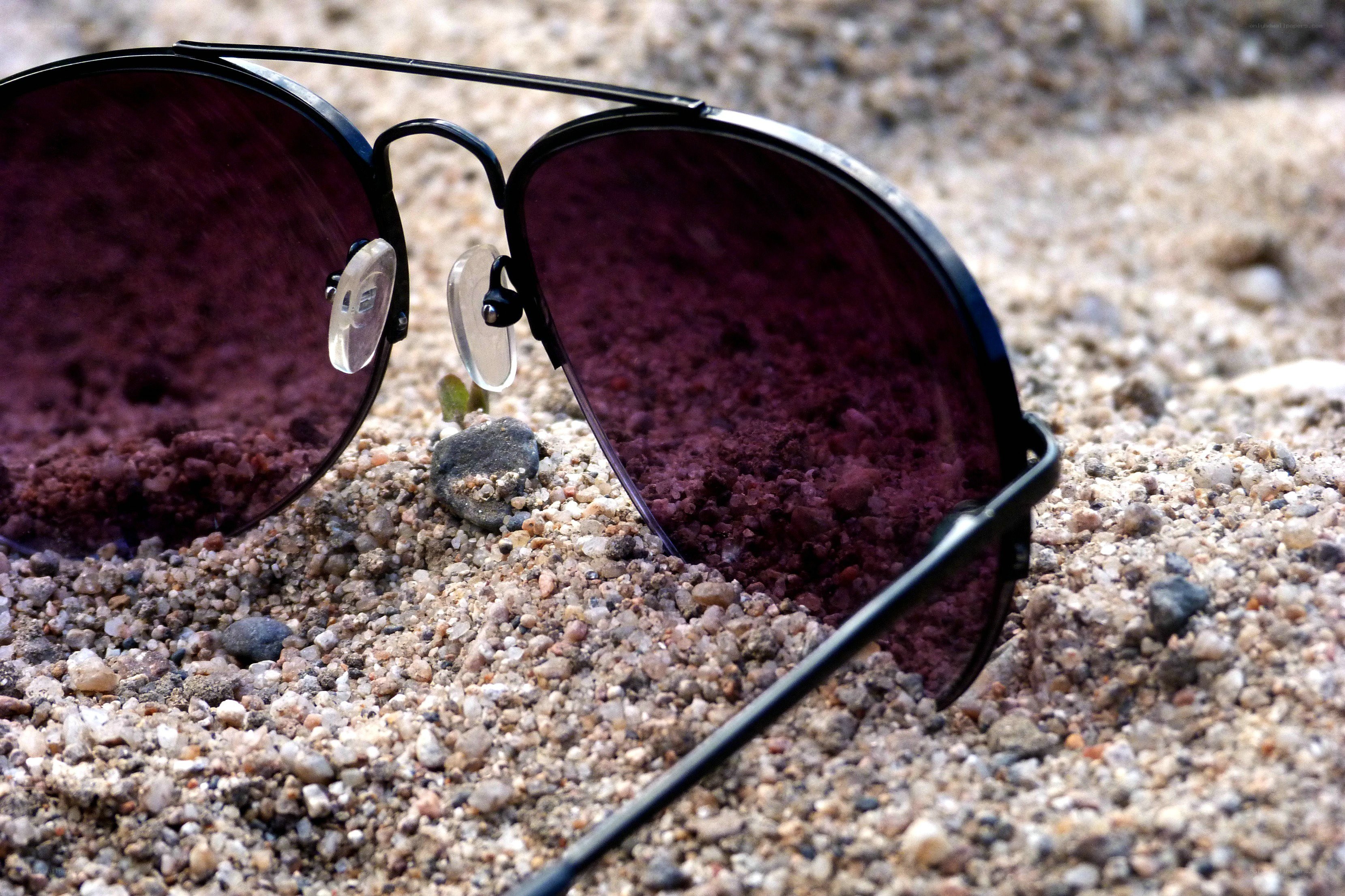 sunglasses on sandy ground