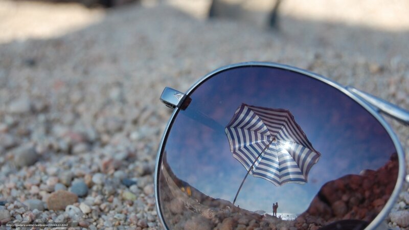 Sunglasses reflecting beach scene