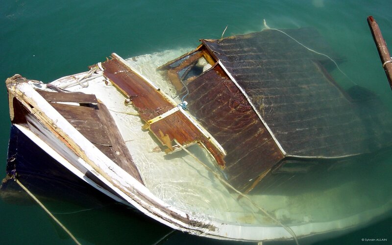 Sunken wooden boat in clear water