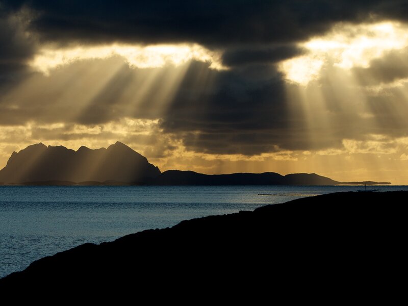 Sunlight beams over coastal mountains