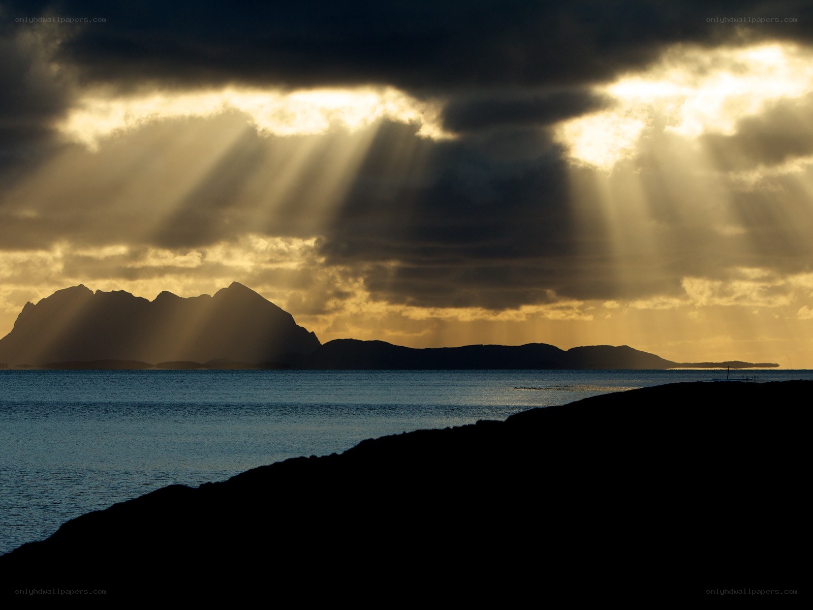 Sunlight beams over coastal mountains