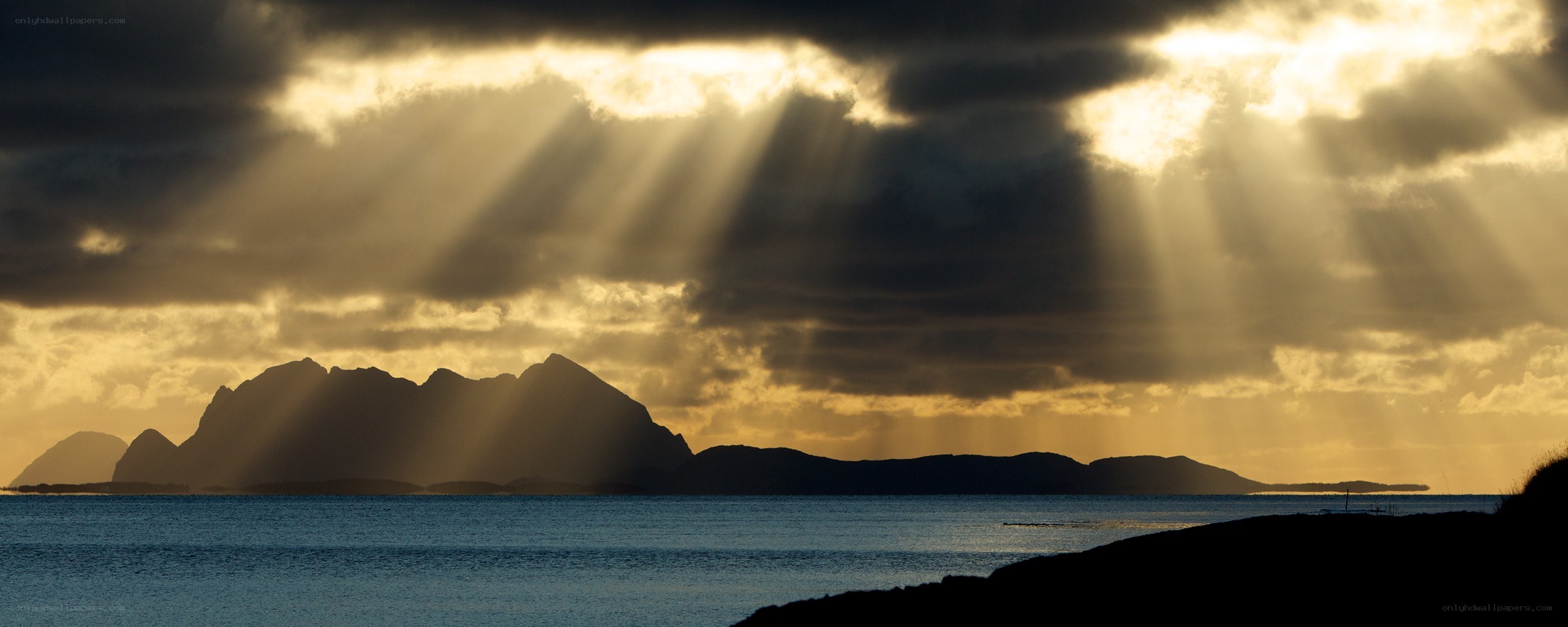 Sunlight beams over coastal mountains