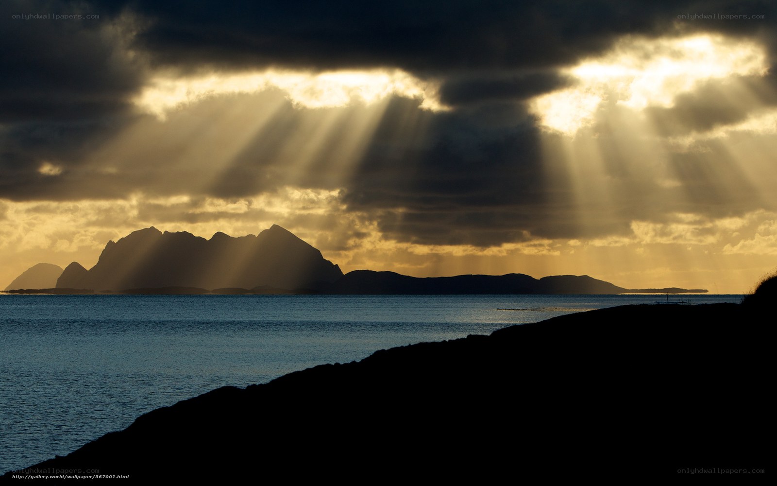 Sunlight beams over coastal mountains