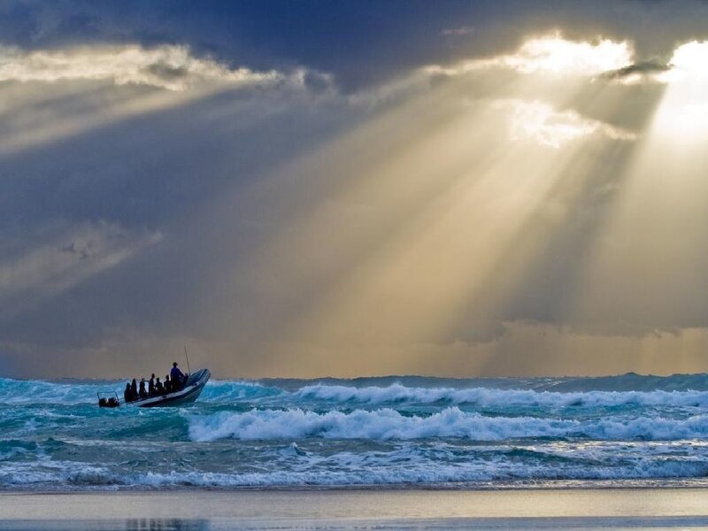 Sunlight beams over ocean boat